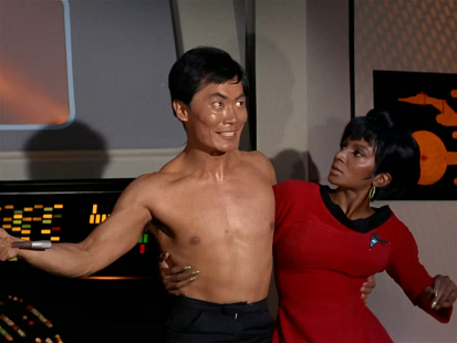 Sulu smiling as he pulls Uhura toward him.